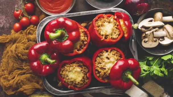 Red bell stuffed paprika peppers in iron cooking pot with various ingredients on side — Stock Video
