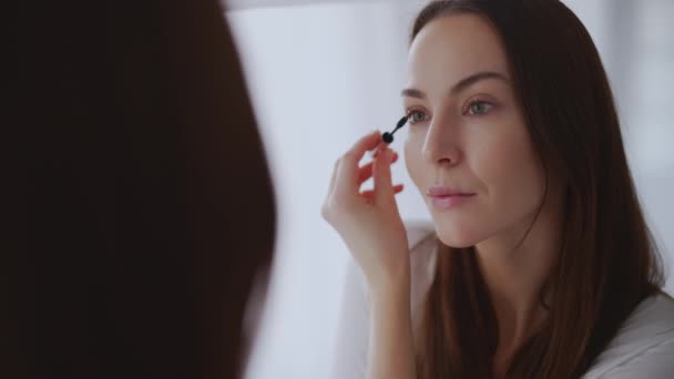 Mujer pintando cejas cerca del espejo — Vídeo de stock