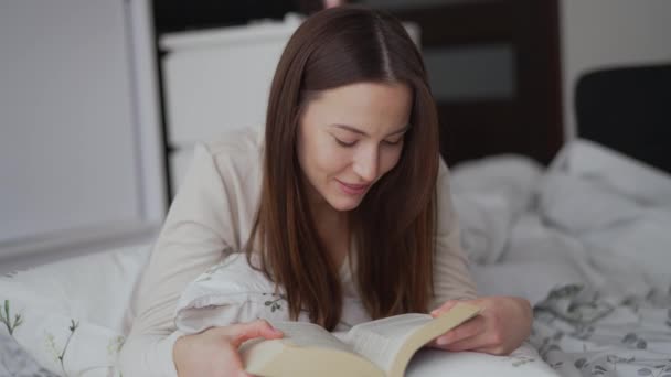 Mujer disfrutando leyendo en la cama — Vídeos de Stock