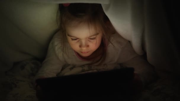 Meisje kijken film op tablet 's nachts — Stockvideo