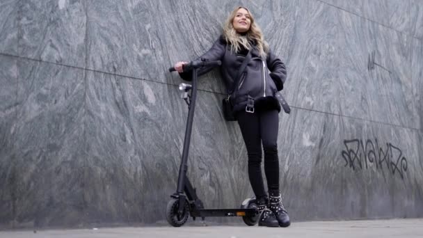 Krásná blondýnka žena pózuje se svým elektrickým skútrem — Stock video