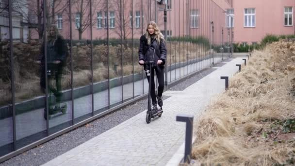 Blond vrouw rijden scooter en het maken van gezicht — Stockvideo