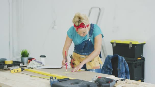 Frau zeichnet in Werkstatt Linie auf Sperrholz — Stockvideo