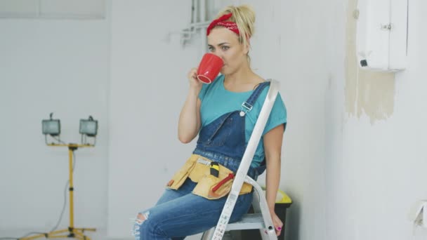 Žena sedící s pitím na žebříku — Stock video