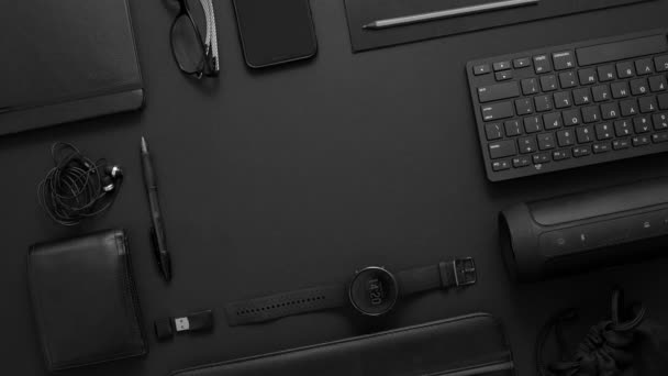 Conceito de negócio. Composição de leigos planos com vários gadgets pretos na superfície preta escura — Vídeo de Stock