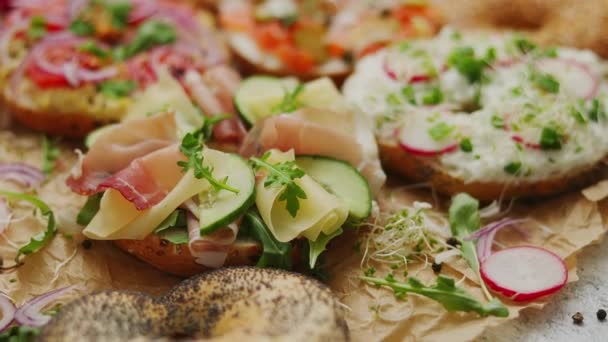 Composição de vários sanduíches caseiros de bagels com gergelim e sementes de papoula — Vídeo de Stock