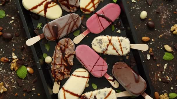 Set heerlijke witte en melkchocolade en aardbeienijs op een stokje geserveerd in metalen dienblad — Stockvideo