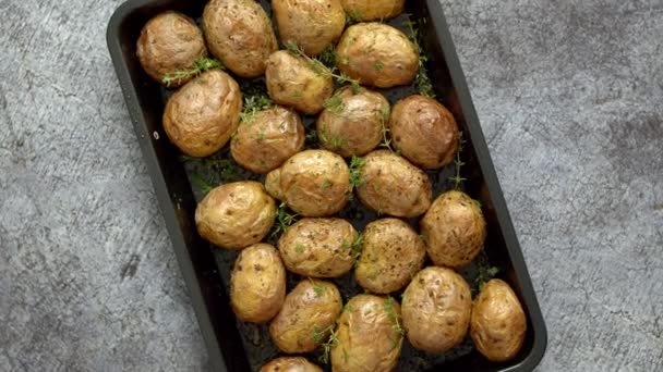 Horno de patatas enteras al horno con condimentos y hierbas en bandeja metálica. Patatas asadas en chaquetas . — Vídeo de stock