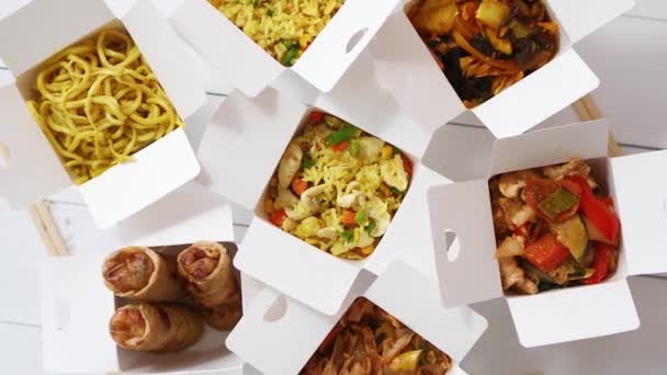 Azjatyckie jedzenie na wynos lub koncepcja dostawy żywności. Pudełka papierowe umieszczone na białym drewnianym stole — Wideo stockowe
