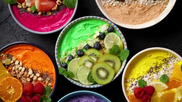 Varios batidos frescos saludables o yogures en cuencos. Con fresas, kiwi, chía, moras — Vídeos de Stock