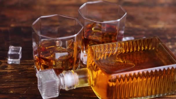 Flaska whisky med två glas placerade på rustika träbord — Stockvideo