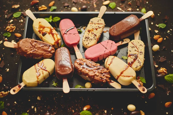 Sortiment av olika glass, vit och mörk choklad, med mandel, rostig bakgrund — Stockfoto