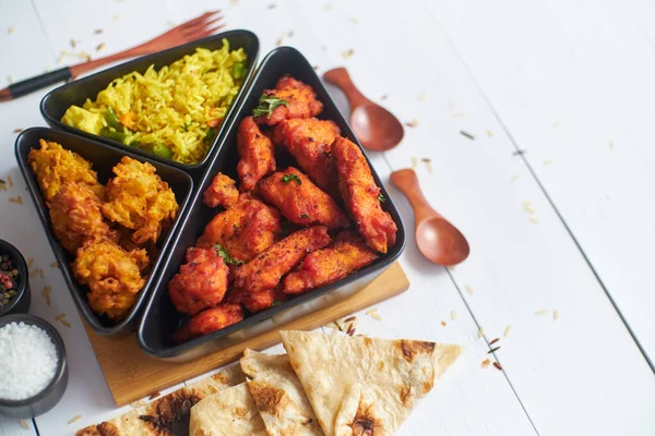 Pittige Indiaanse gebakken kip geserveerd met curry plantaardige rijst, ui bhajia, naan brood — Stockfoto