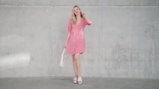 Модна жінка біля бетонної стіни — стокове відео
