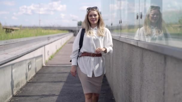 Jovem empresária caminhando fora do edifício moderno — Vídeo de Stock