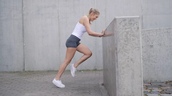 Female athlete exercising near barrier — Stock Photo, Image