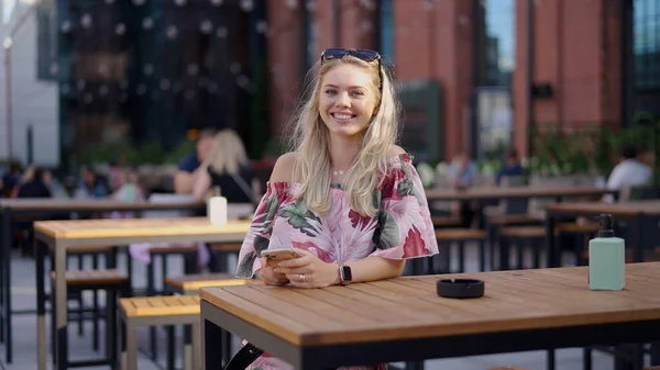 Glad kvinna med smartphone på café — Stockfoto