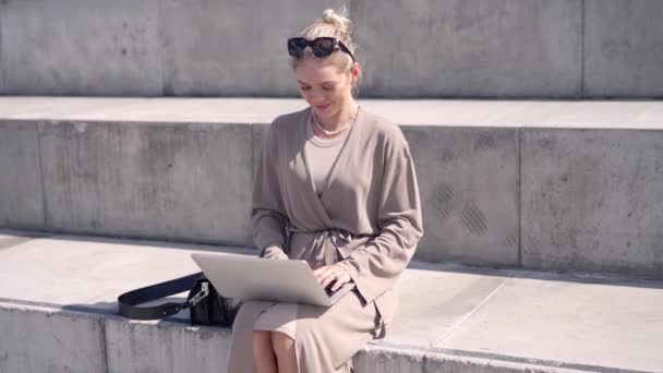 Жіночий фрілансер використовує ноутбук на вуличних сходах — стокове відео