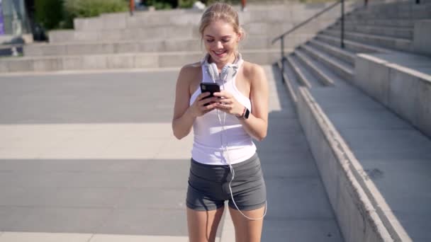 Deportista alegre usando smartphone en la calle — Vídeo de stock