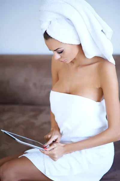 Frau mit Badetuch und Tablet-Computer — Stockfoto