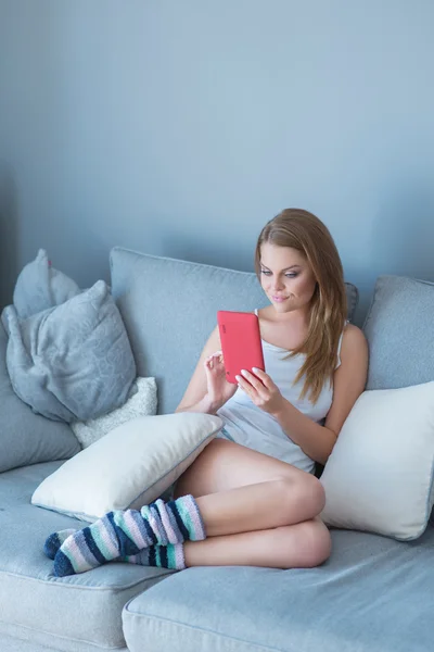 Young lady comfortably sitting on a couch — Stock Photo, Image