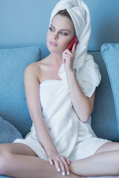 Женщина в банном полотенце разговаривает по мобильному телефону — стоковое фото