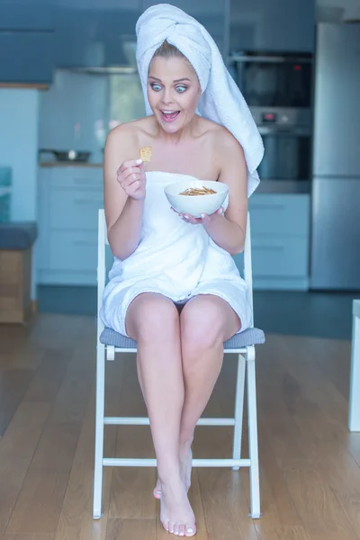 Şaşırmış kadın kase aperatifler ile banyo havlusu — Stok fotoğraf