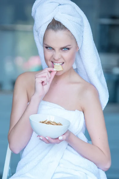 Mulher em toalha de banho comer lanches da tigela — Fotografia de Stock