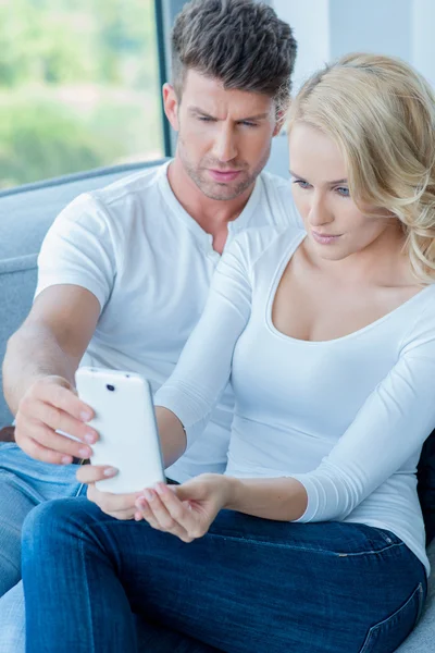 Pareja leyendo un mensaje de texto con consternación — Foto de Stock