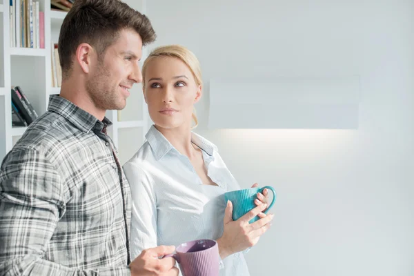 Aantrekkelijke paar staande in hun woonkamer — Stockfoto