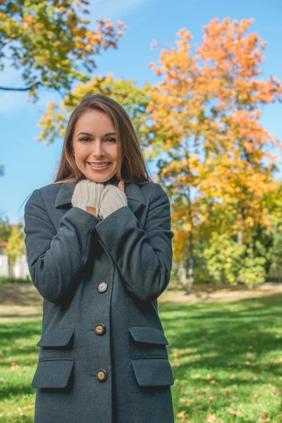 Usmívající se krásná žena chlazení v šedém kabátě — Stock fotografie