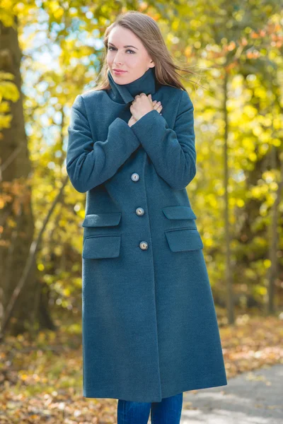 Mooie vrouw met grijze vacht op aard achtergrond — Stockfoto