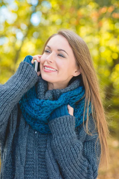 Feliz mujer de moda charlando en un móvil — Foto de Stock