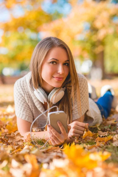 Genç kadın bir parkta onun müzik ile rahatlatıcı — Stok fotoğraf