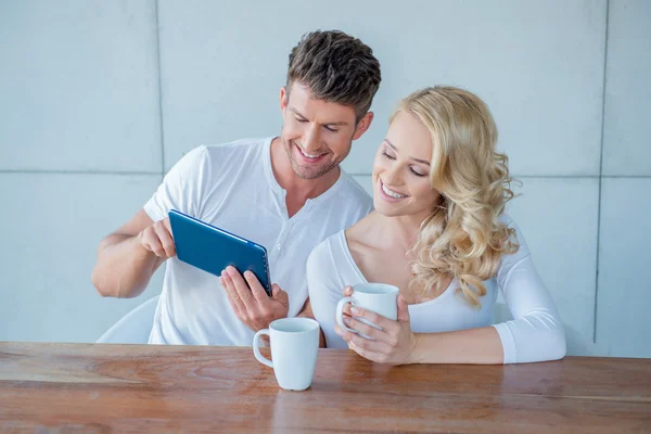 Casal feliz navegando na web em um tablet — Fotografia de Stock