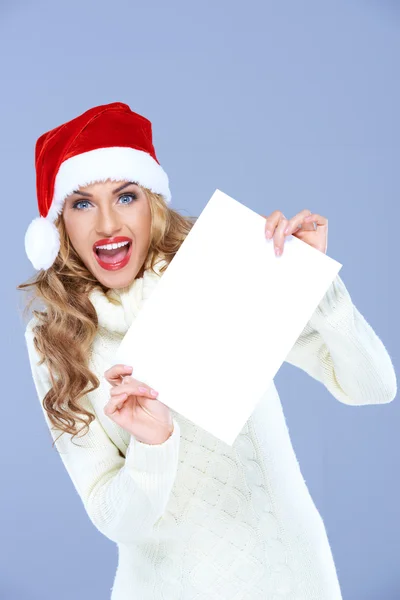 Junge Frau mit Weihnachtsmütze und leerem Schild — Stockfoto