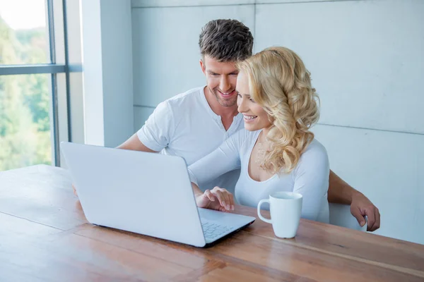 Pareja sonriendo mientras revisan sus redes sociales — Foto de Stock