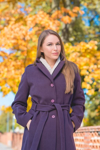 Jolie jeune femme en manteau violet à l'automne — Photo