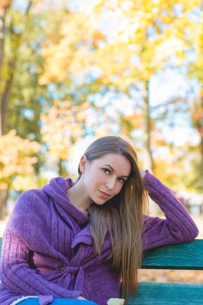 Mujer bonita en traje de otoño sentada en el banco —  Fotos de Stock