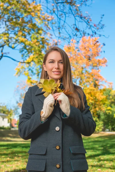 Pretty Lady en otoño de moda sosteniendo hojas secas — Foto de Stock