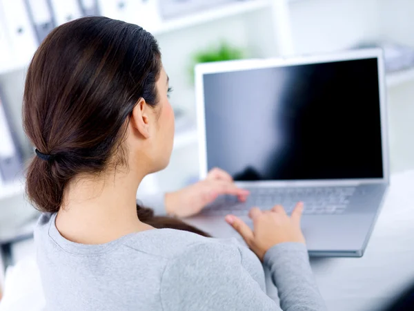 Visão traseira da mulher em seu laptop — Fotografia de Stock