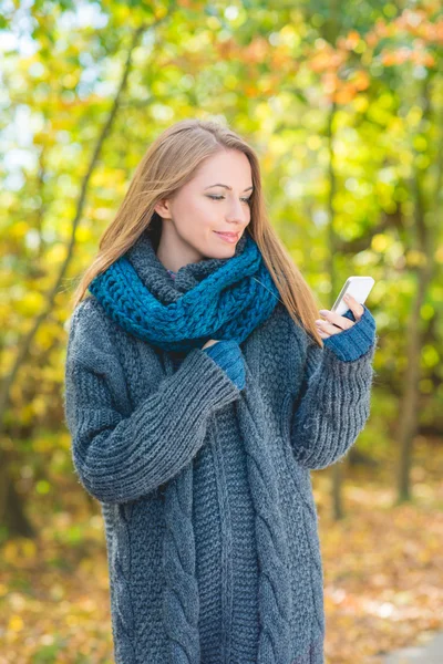 Mujer joven usando un móvil al aire libre en otoño — Foto de Stock