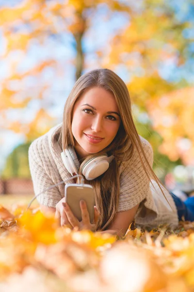 Genç kadın bir parkta onun müzik ile rahatlatıcı — Stok fotoğraf