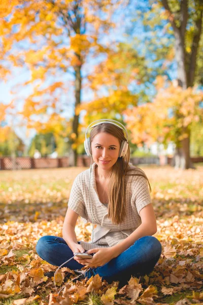 Γυναίκα που κάθεται στο έδαφος ακούει μουσική Ipod — Φωτογραφία Αρχείου