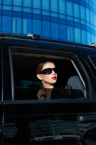 Femme sérieuse dans les nuances à l'intérieur de voiture coûteuse — Photo