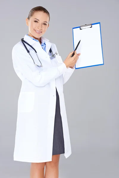 医生或护士指着一个空白的剪贴板 — 图库照片