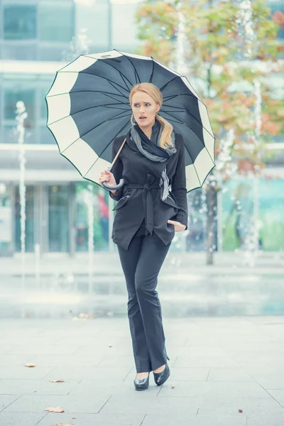 Junge Frau geht mit geöffnetem Regenschirm — Stockfoto