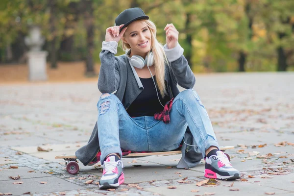 Žena s roztomilý úsměv na skate desky — Stock fotografie