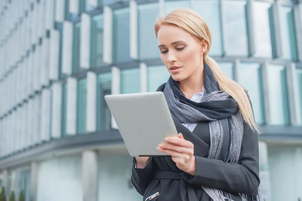 Junge Geschäftsfrau checkt ihr Tablet — Stockfoto