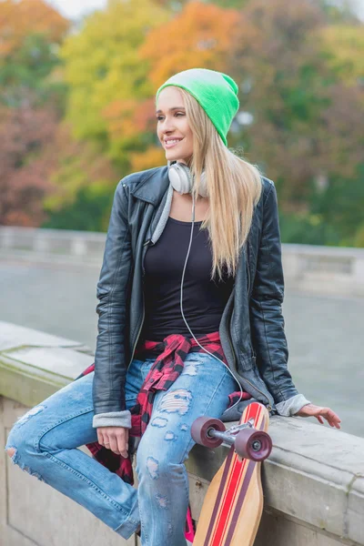 Jovem mulher na moda casual com seu skate board — Fotografia de Stock